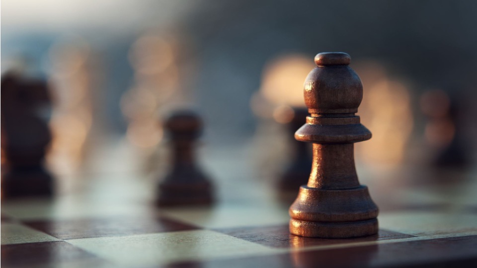 A wooden chess piece in focus on a chessboard
