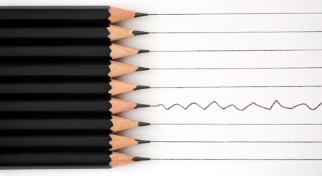 Pencils drawing lines, with one following a different path